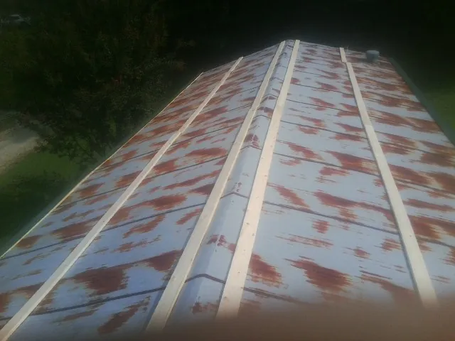 Rusted metal roof panels with new wood purlins before replacement — Storm Damage Roof Repair in Blairs by Roofing Brothers