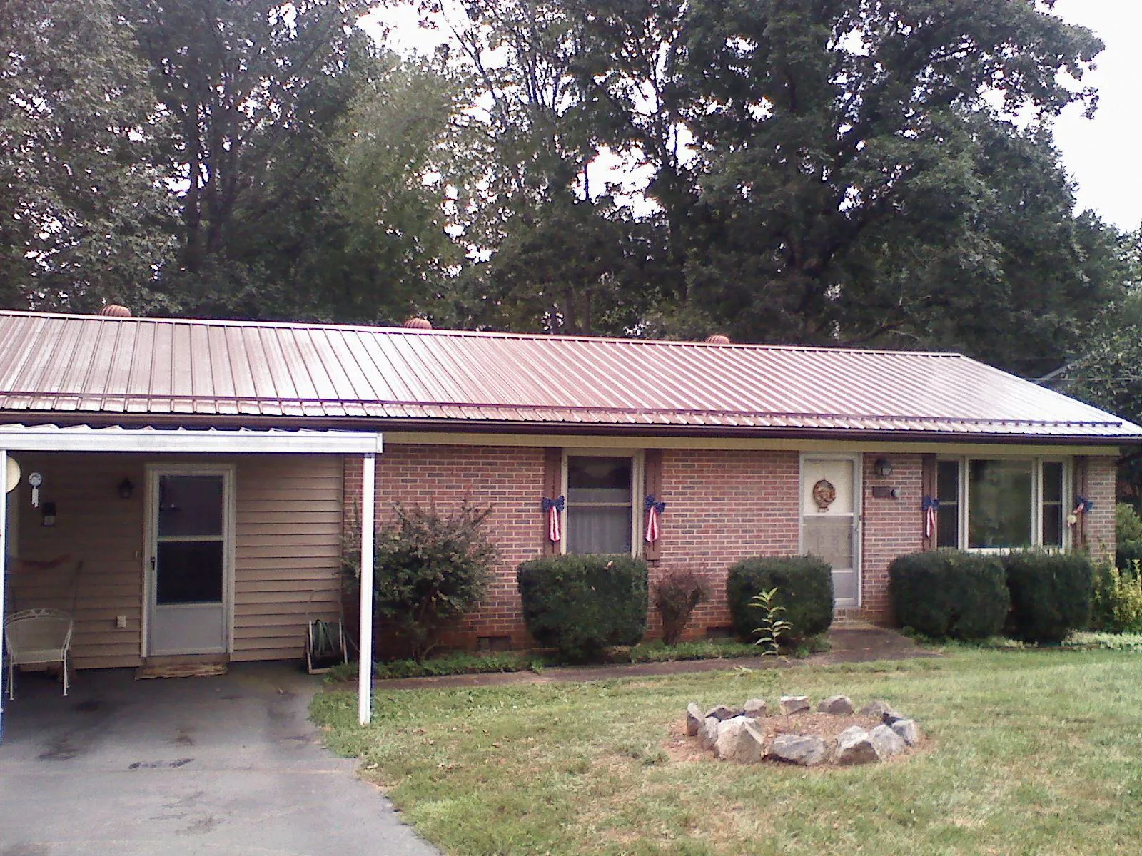 Bronze metal roof and carport on a brick ranch home — Roof Repair work by our crew in Blairs